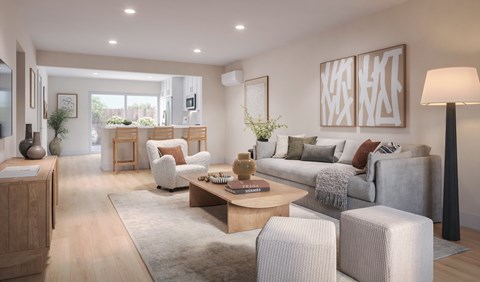 A modern living room with a grey sofa, wooden coffee table, and a large window.