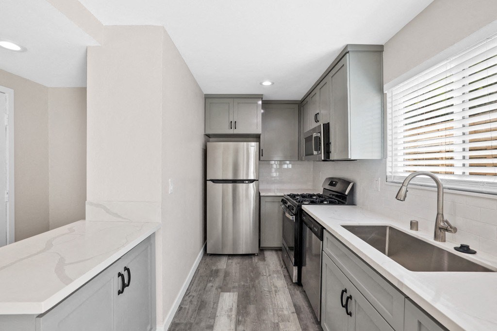a kitchen with white cabinets and a stainless steel refrigerator