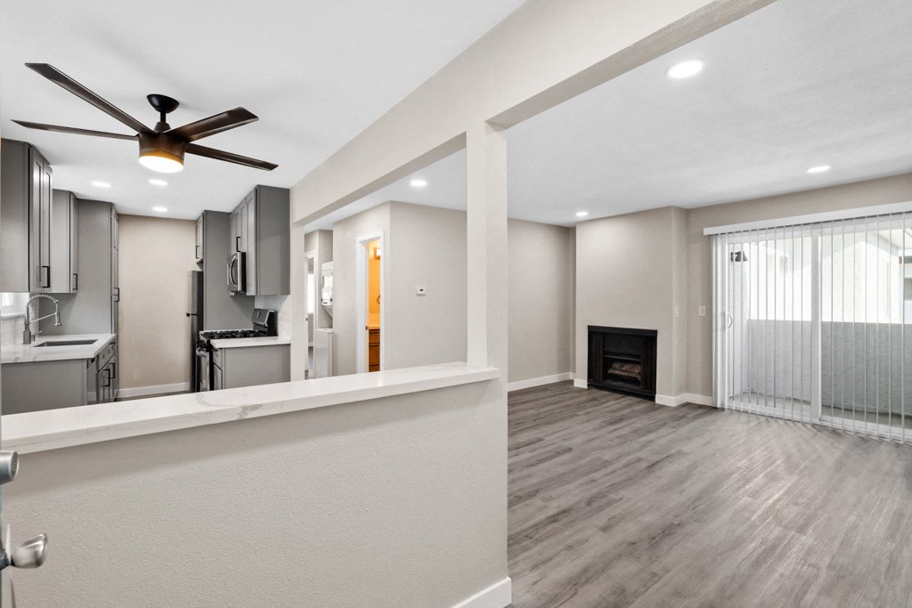a living room with a ceiling fan and a fireplace
