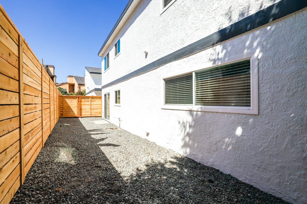 the side of a white house with a wooden fence
