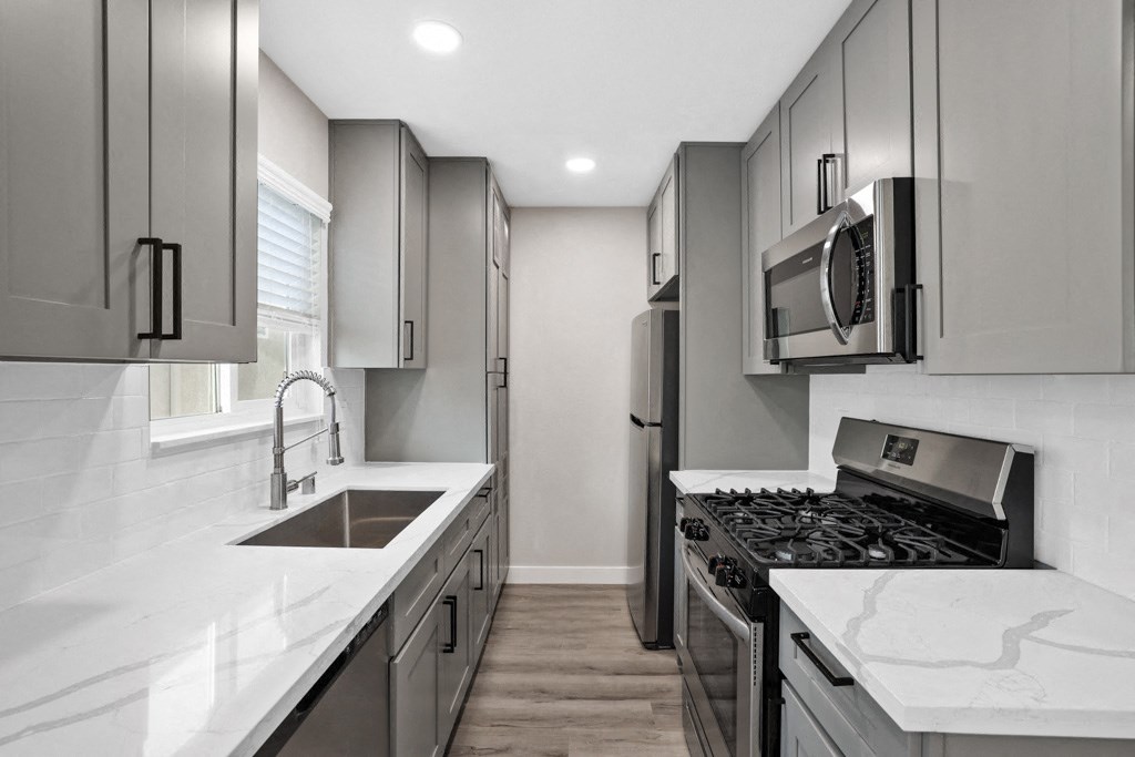 a kitchen with stainless steel appliances and marble counter tops