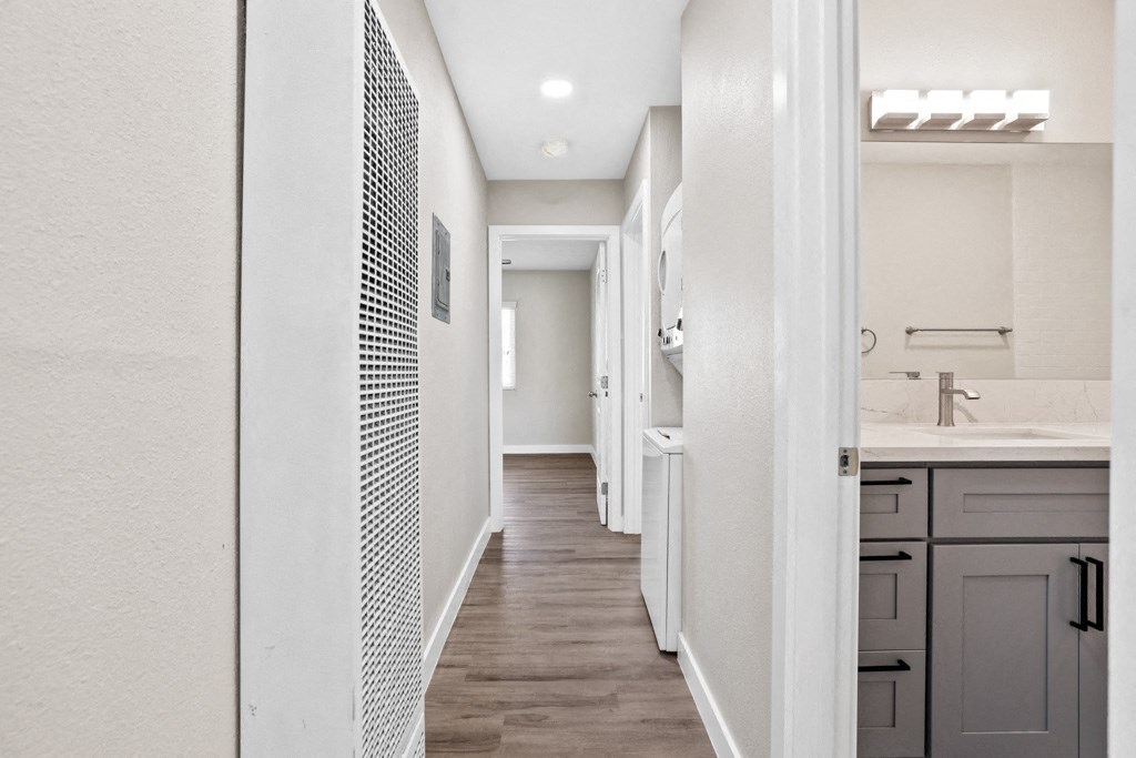 a spacious bathroom with a long hallway with a sink and a mirror