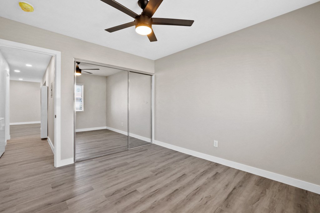 the living room of an empty house with a ceiling fan