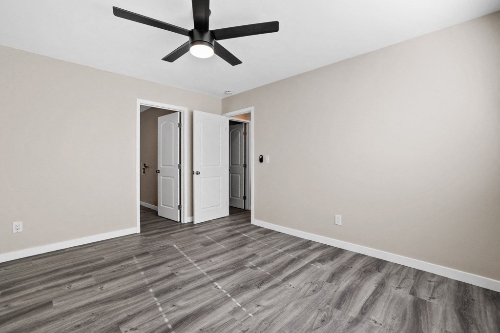 the living room of an empty house with a ceiling fan