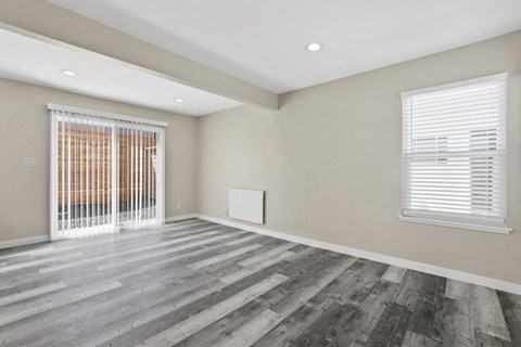 the living room of a new home with a large window and wood flooring