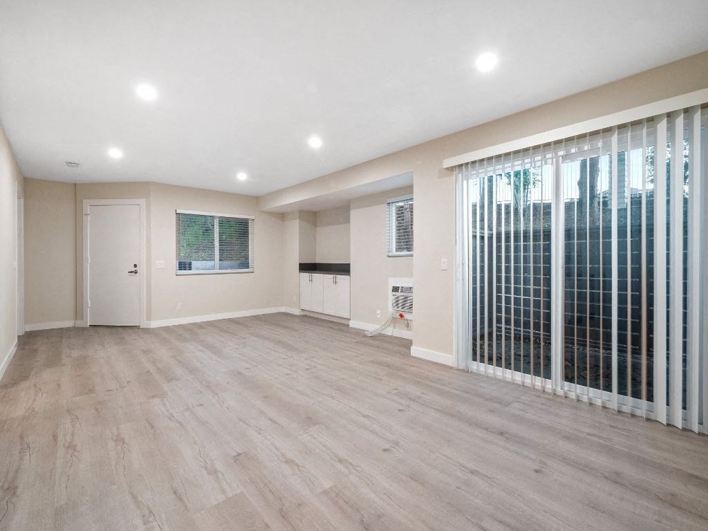 an empty living room with a large window and sliding glass doors