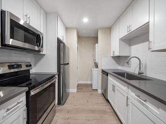 a kitchen with white cabinets and stainless steel appliances