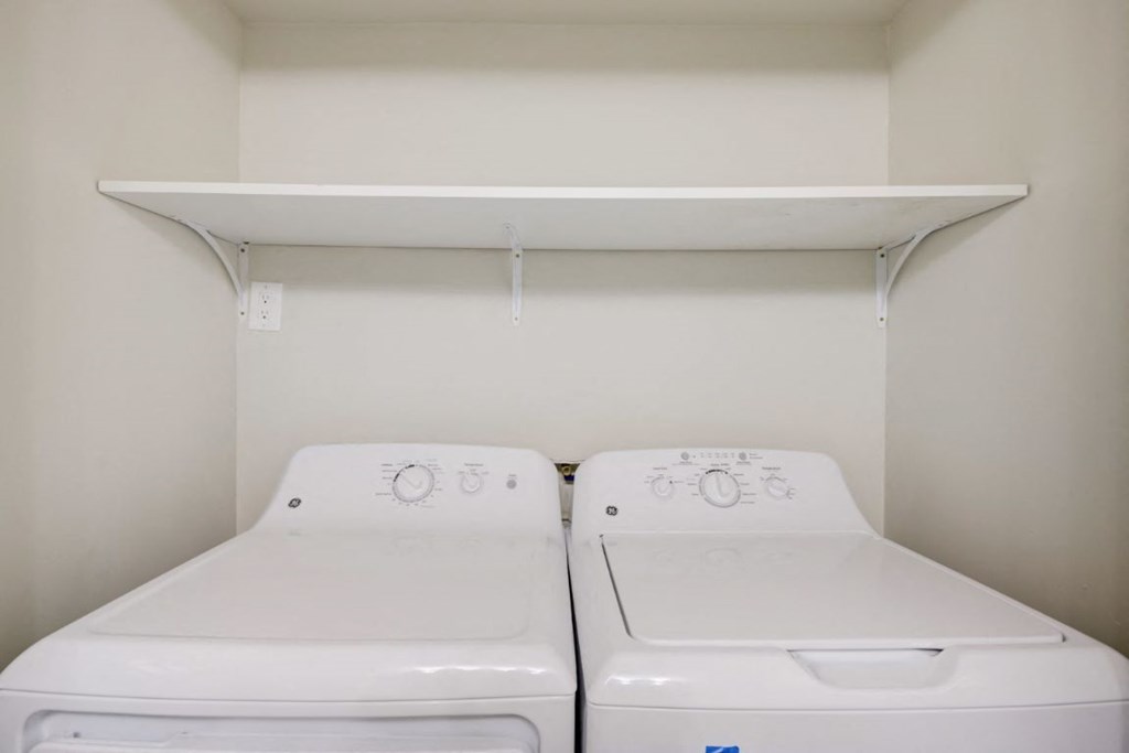 a laundry room with two washes and a shelf above them