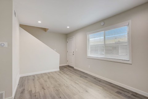 a living room with a large window and a white wall