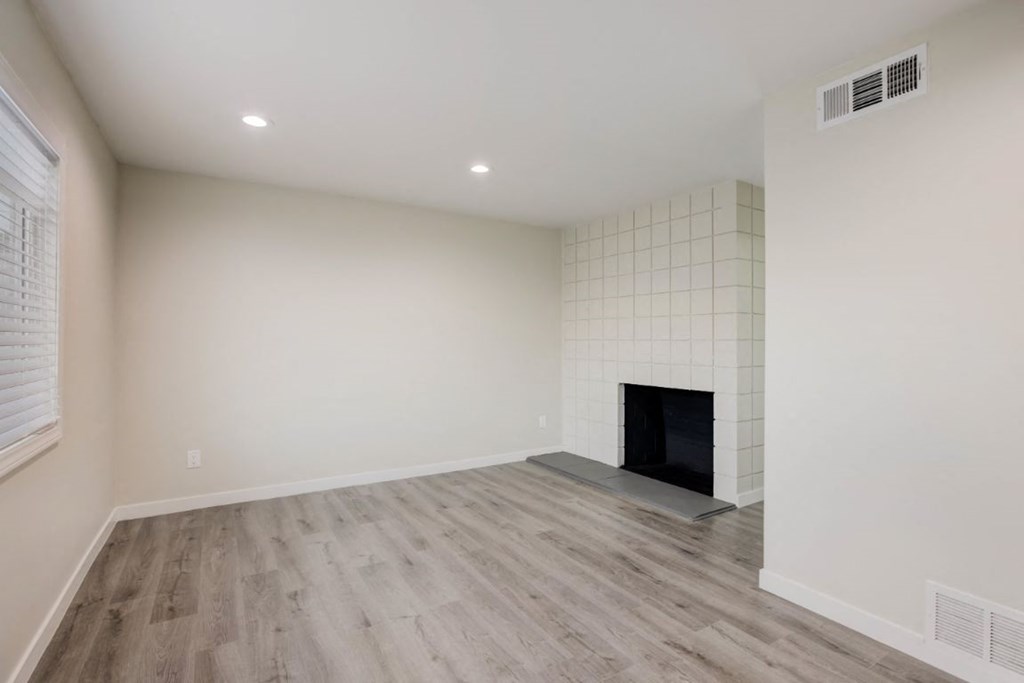 a living room with white walls and a fireplace