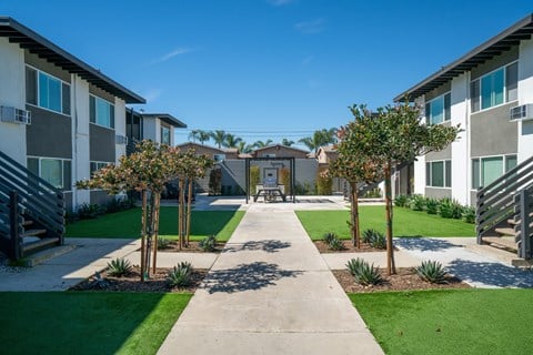 A sunny day at a residential area with apartment buildings and a walkway.