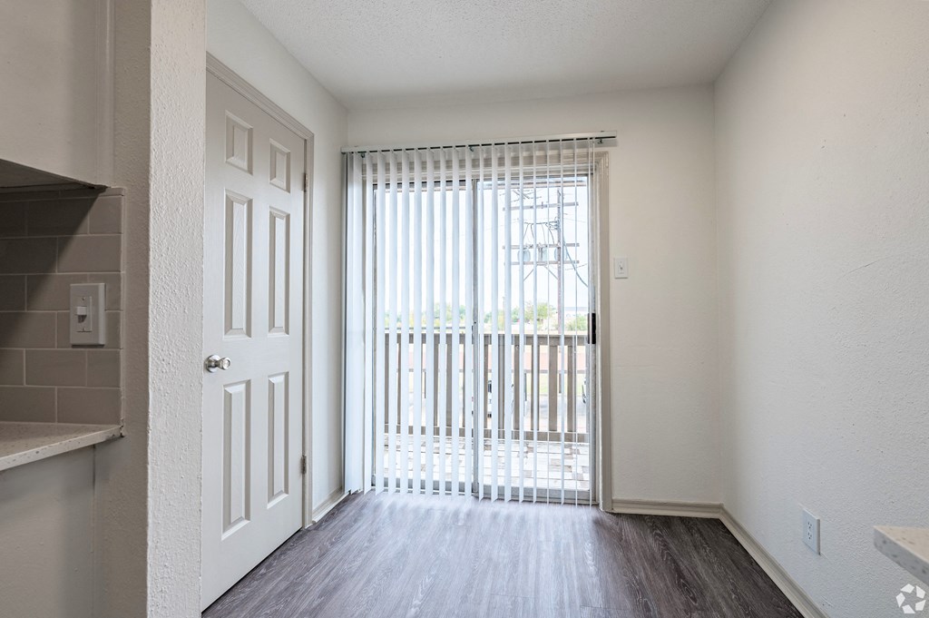 an empty living room with a door to a balcony