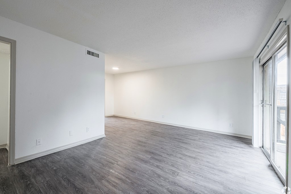 an empty living room with white walls and wood flooring