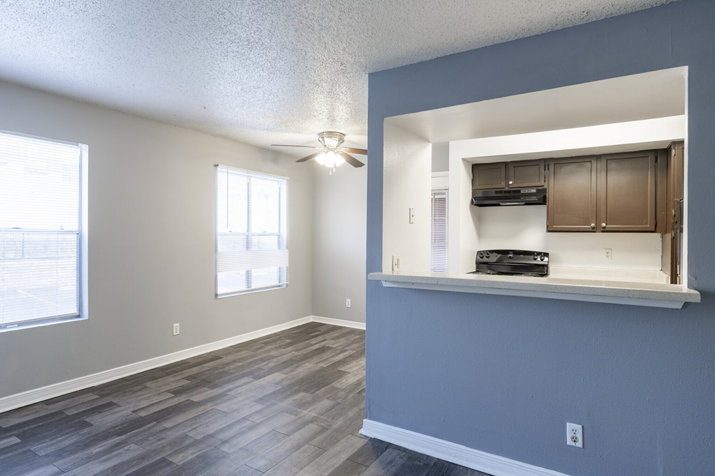 A room with a window and a fan on the ceiling.