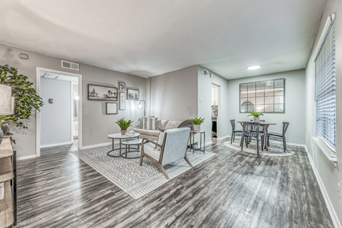 A living room with a grey sofa and a glass table.