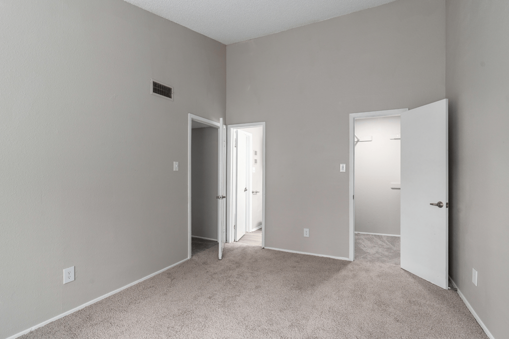 a bedroom with a carpeted floor and a door to a closet at Anson at North Hills, Raleigh