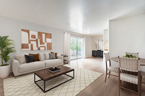 A modern living room with a white couch, a coffee table, and a large painting on the wall.