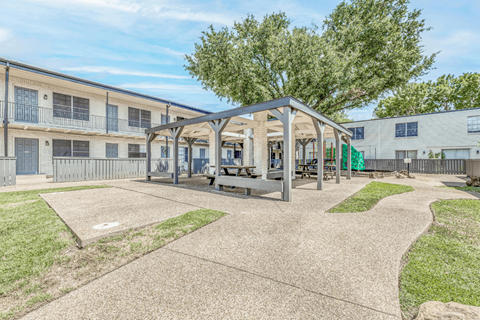 A playground area with a wooden structure and a concrete ground.