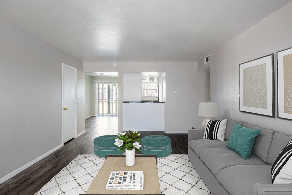 A living room with a grey couch, a coffee table, and a white tiled floor.