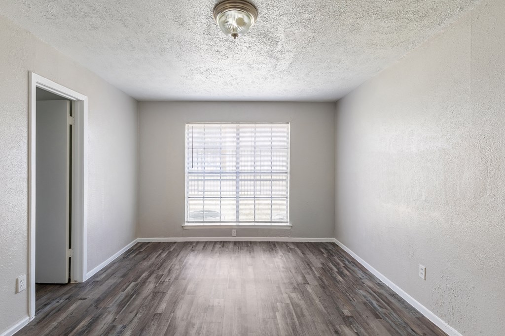 A room with a window and wooden floors.
