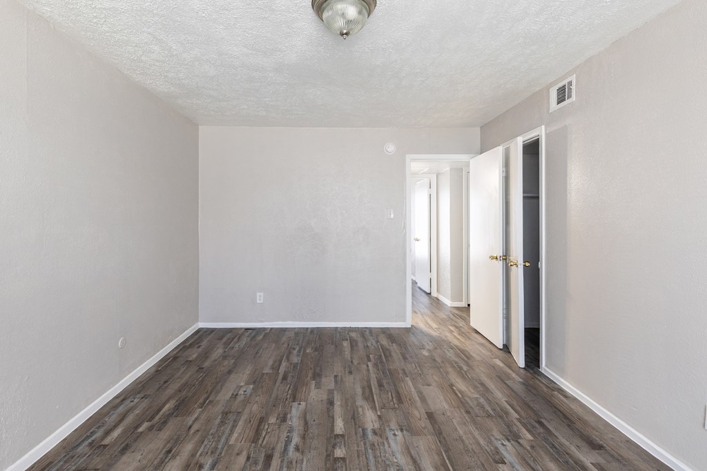A room with wooden flooring and white walls.