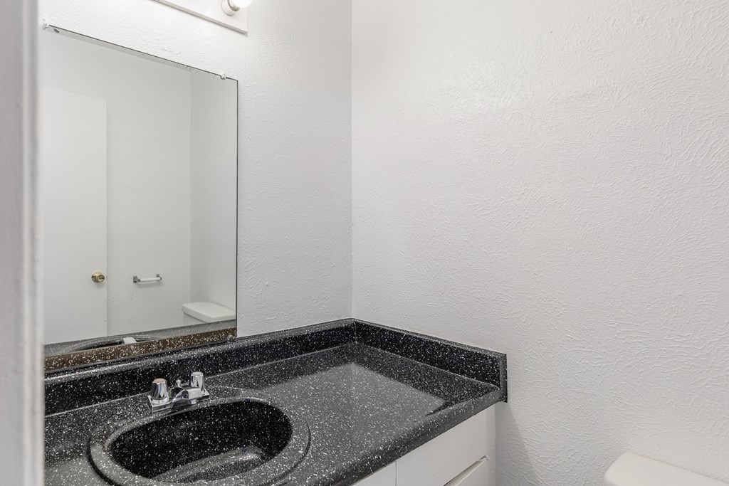 A bathroom with a sink and mirror.
