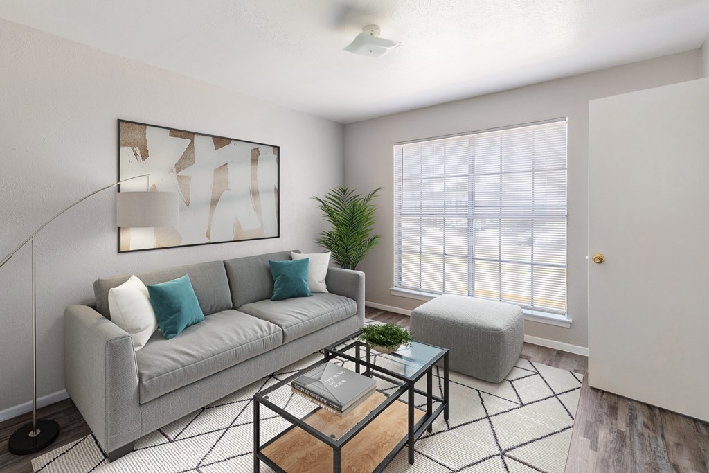 A living room with a grey couch, a coffee table, and a floor lamp.