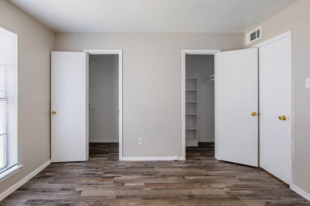 A room with white doors and a wooden floor.