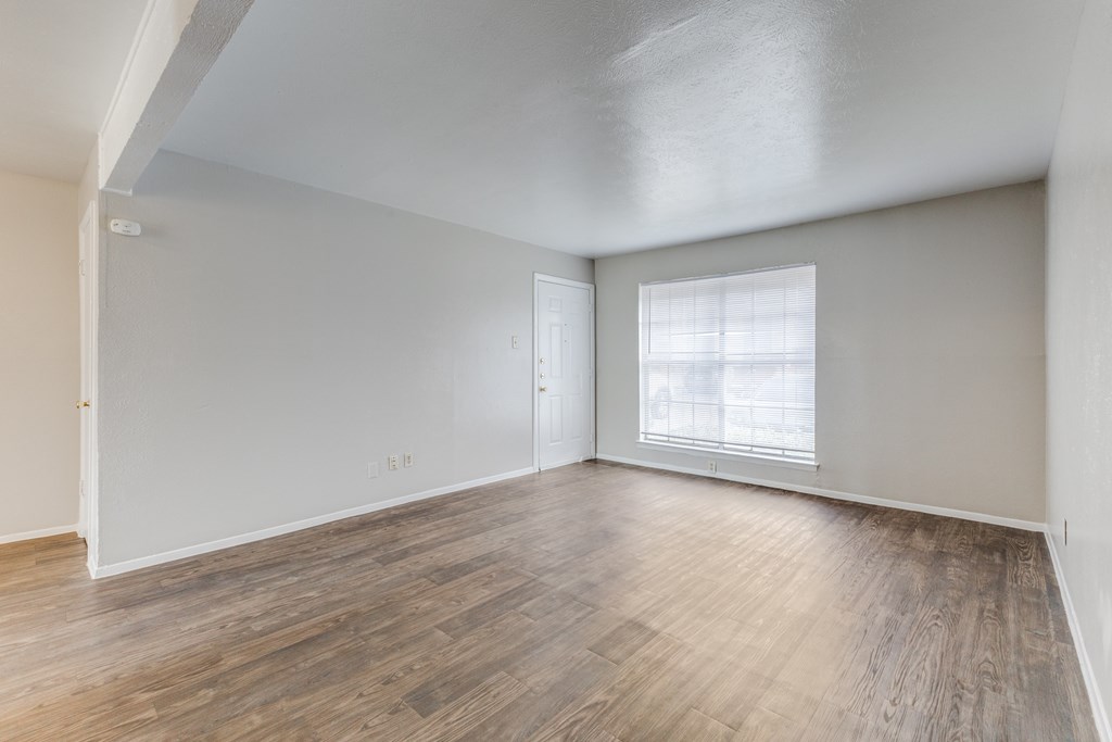 A room with wooden flooring and a window letting in light.