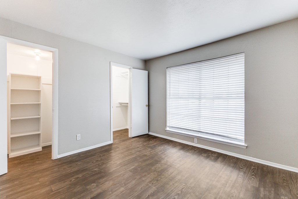 A room with a window and a shelf.