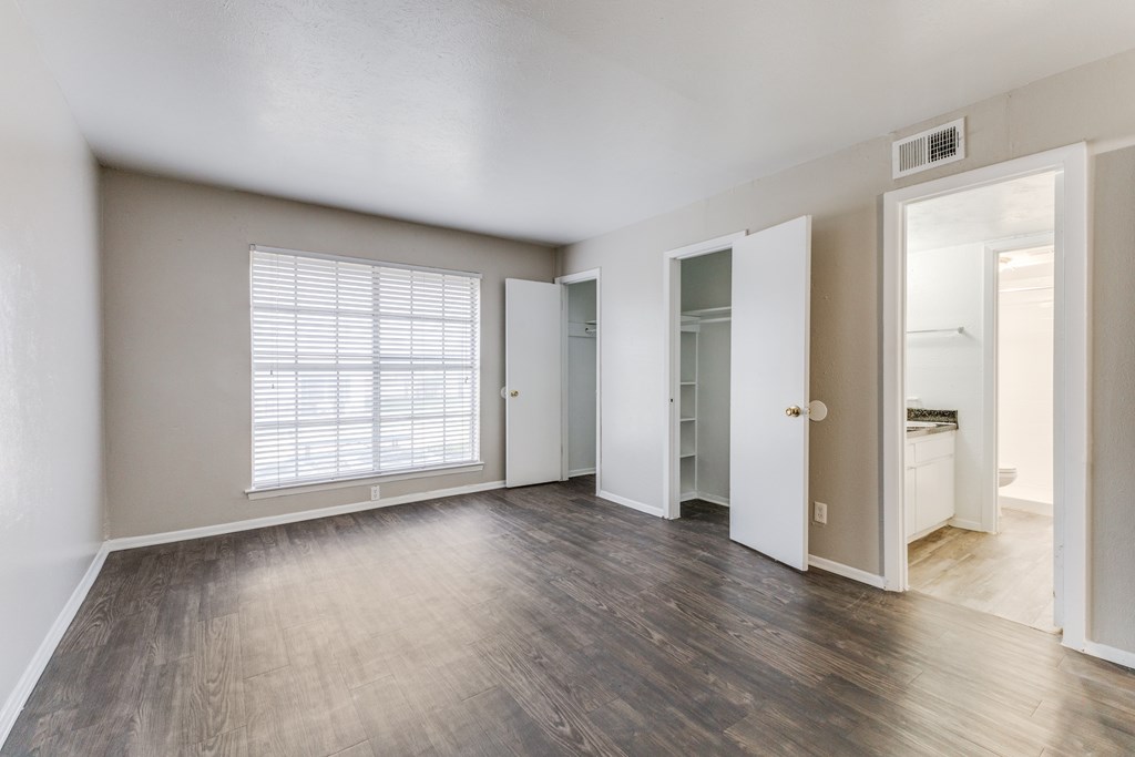 A room with a window and wooden floors.