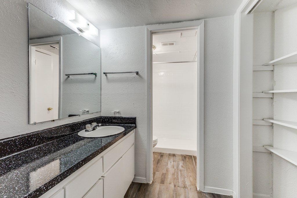 A bathroom with a sink, mirror, and a white door.