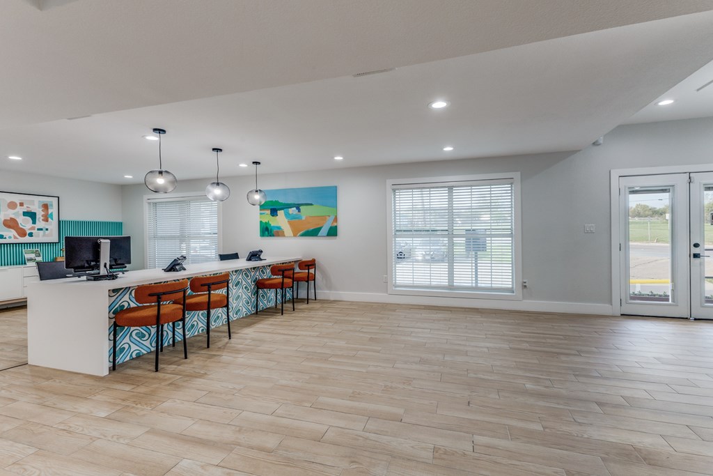 A spacious room with a long table and chairs.