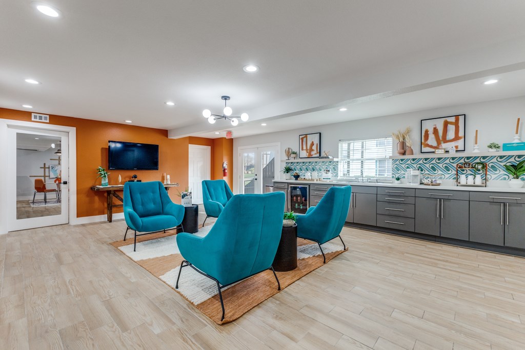 A living room with a television, two chairs, and a table.