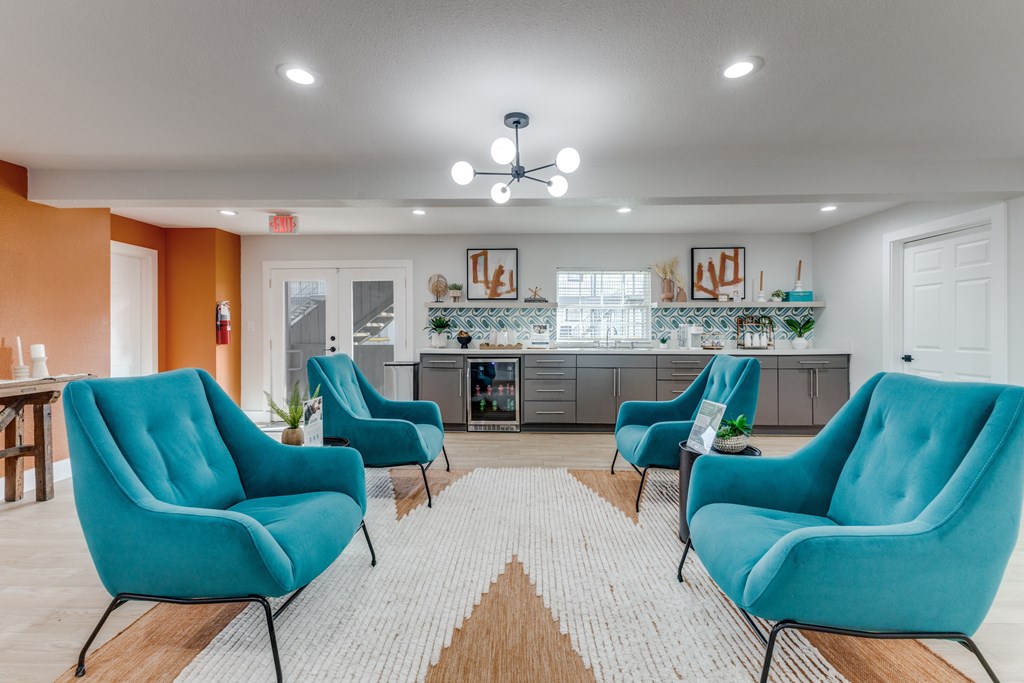 A living room with blue chairs and a white ceiling fan.