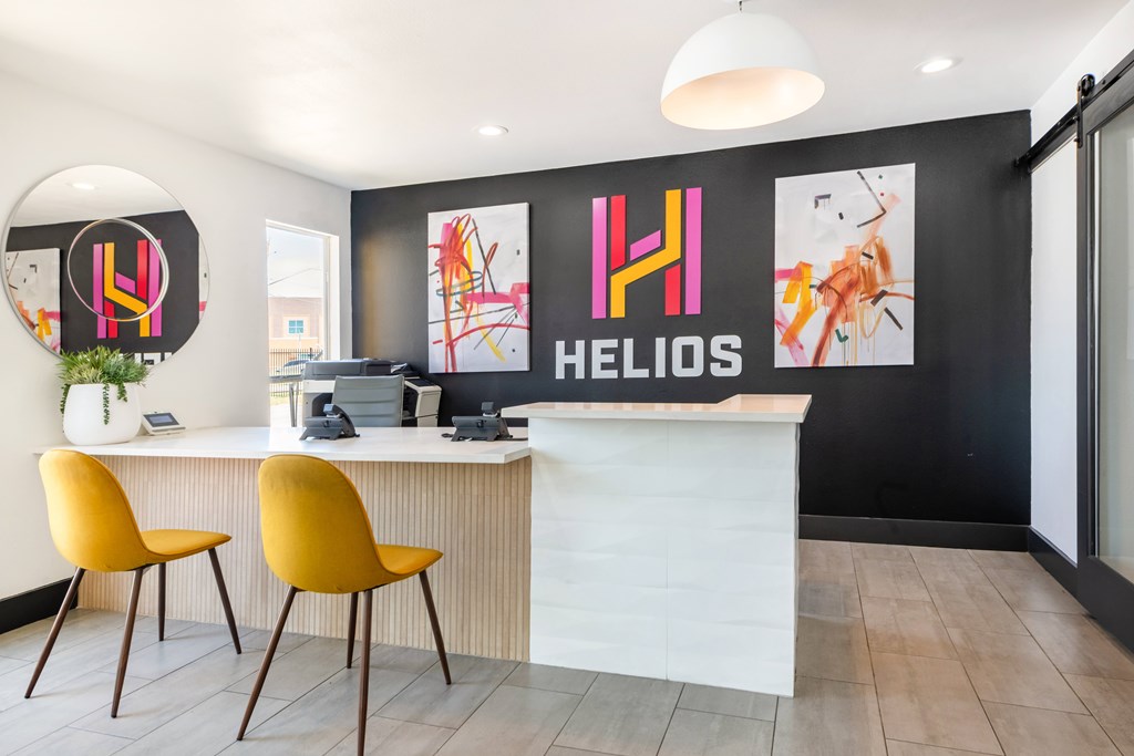 A modern office space with a white desk and two yellow chairs.