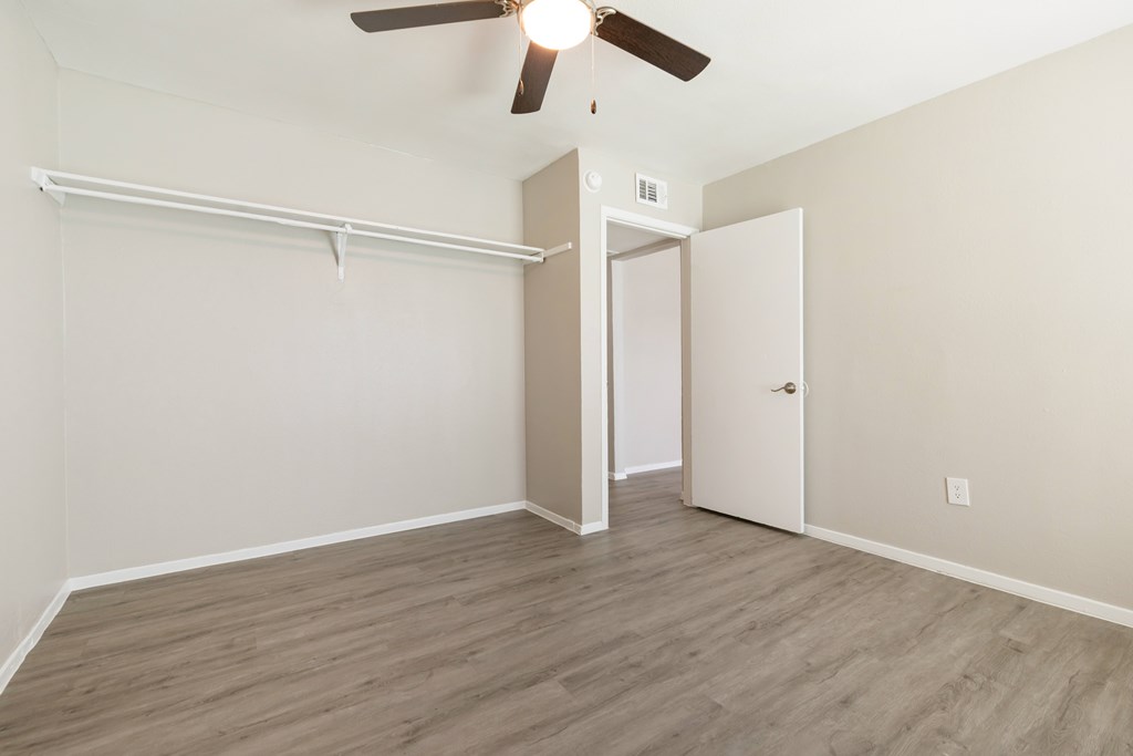 A room with a ceiling fan and a door.