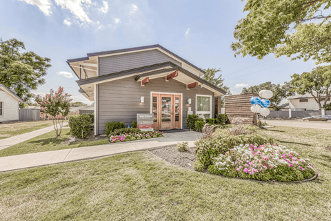A modern house with a grey exterior and a landscaped front yard.