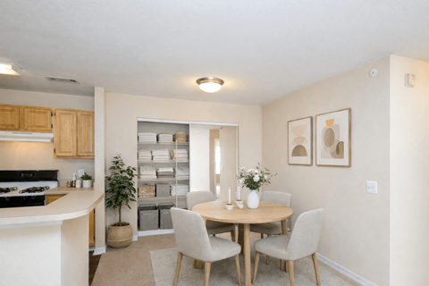 A kitchen with a dining table and chairs.