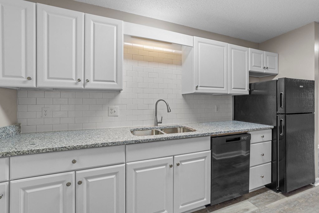 kitchen with quartz countertops and white backsplash at Bennett, North Carolina