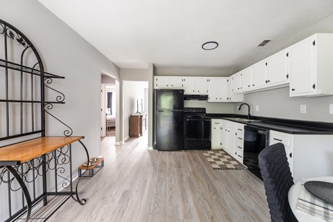 A kitchen with white cabinets and a black oven.
