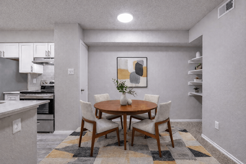 Dining area with round table and modern chairs at The Meadows Apartments, Texas
