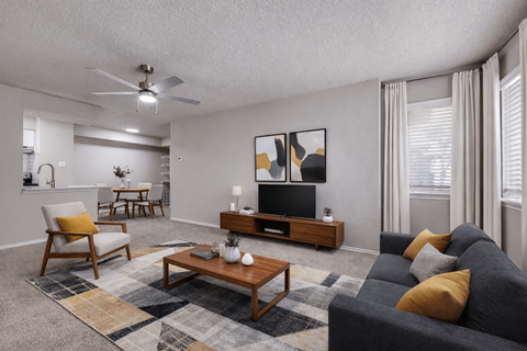 A living room with a grey couch, a wooden coffee table, and a painting on the wall.