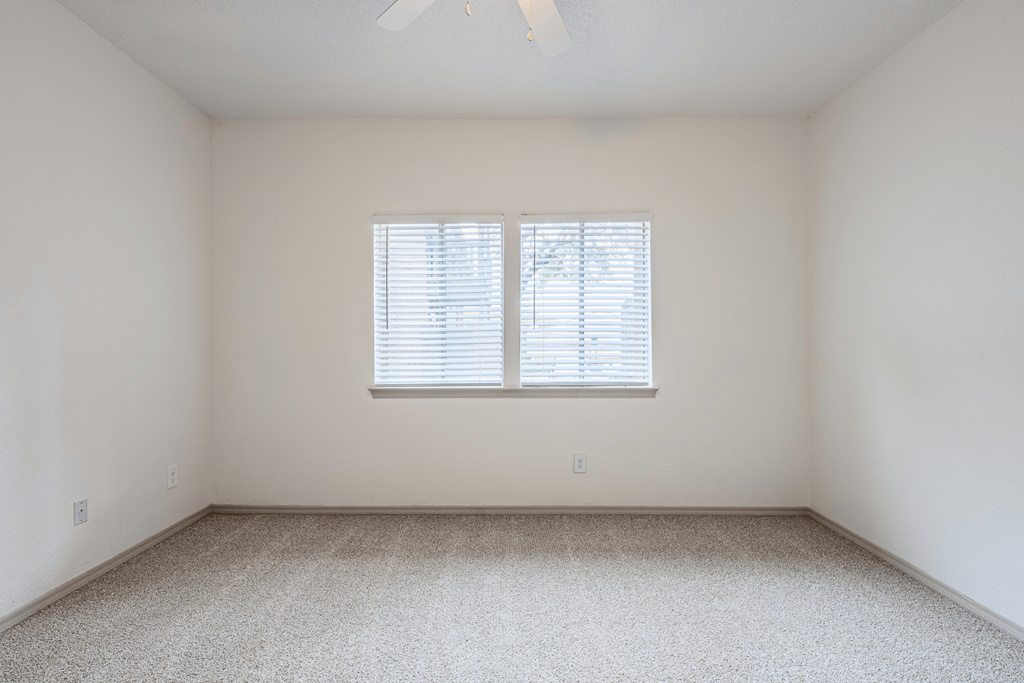 an empty room with white walls and a window