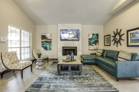 A living room with a fireplace and a television on the wall.