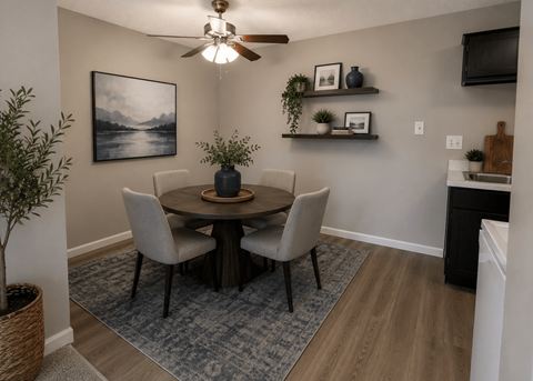 A dining room with a table, chairs, and a ceiling fan.