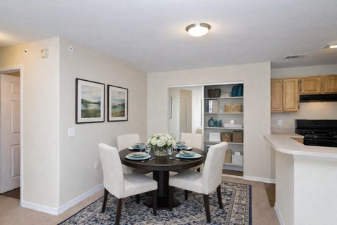 Dining room with round table and upholstered chairs at Walnut Ridge Apartments, North Carolina