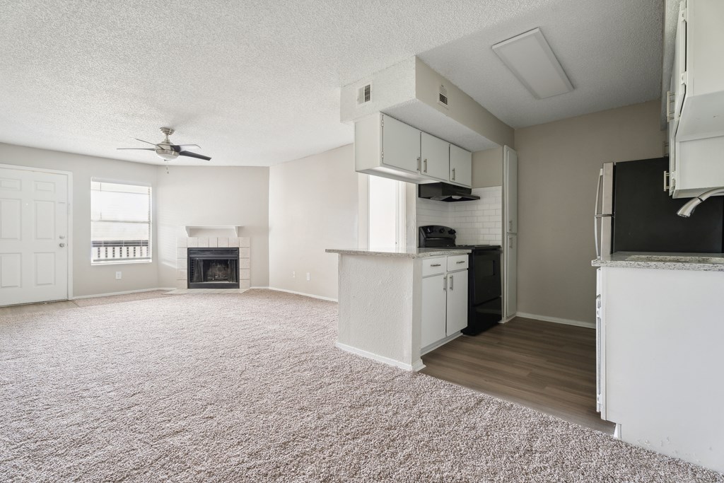A living room with a fireplace and a ceiling fan. at Anson at North Hills, North Carolina