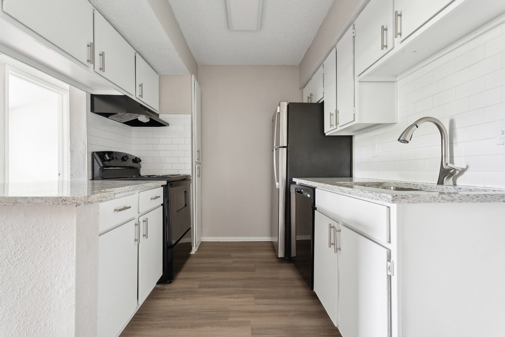 A kitchen with white cabinets and a black refrigerator. at Anson at North Hills, Raleigh, North Carolina