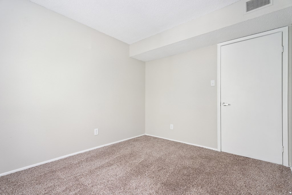 A room with a carpeted floor and a white door. at Anson at North Hills, North Carolina, 27604